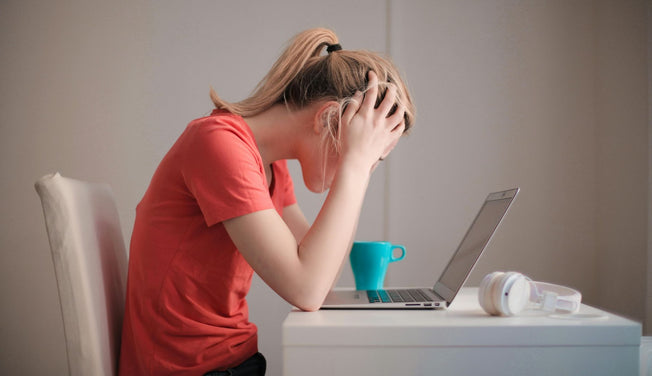 an anxious woman slumps over her laptop in frustration – Dr. Dabber